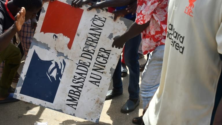Des manifestants tiennent un panneau de l ambassade de France apres un rassemblement en soutien aux militaires putschistes au Niger le 30 juillet 2023 a Niamey 1682322
